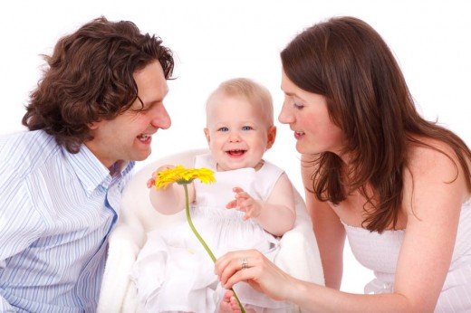 Man and Woman Holding Yellow Flower With Baby